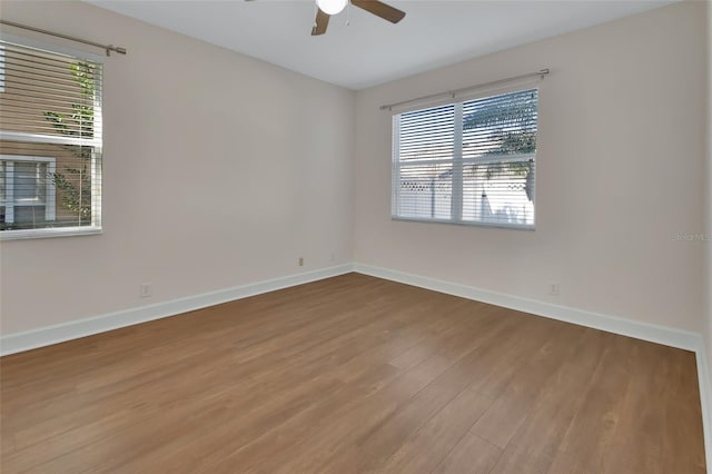 unfurnished room featuring a ceiling fan, baseboards, and wood finished floors