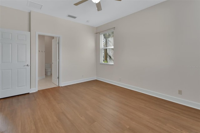 spare room with baseboards, ceiling fan, visible vents, and light wood-style floors