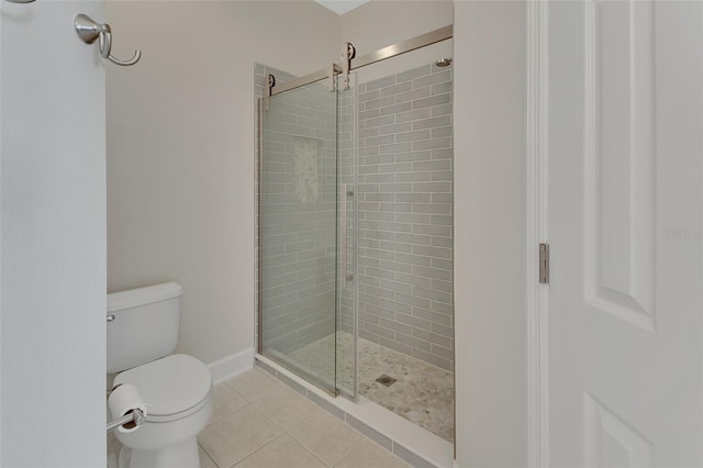 full bath featuring toilet, tile patterned flooring, and a shower stall