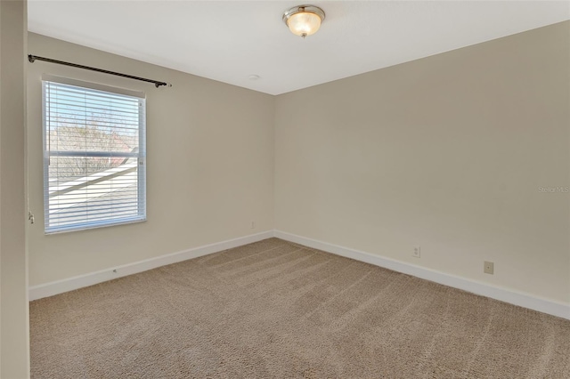 empty room with baseboards and light colored carpet