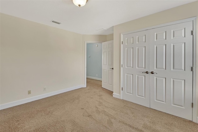 unfurnished bedroom with a closet, carpet flooring, visible vents, and baseboards