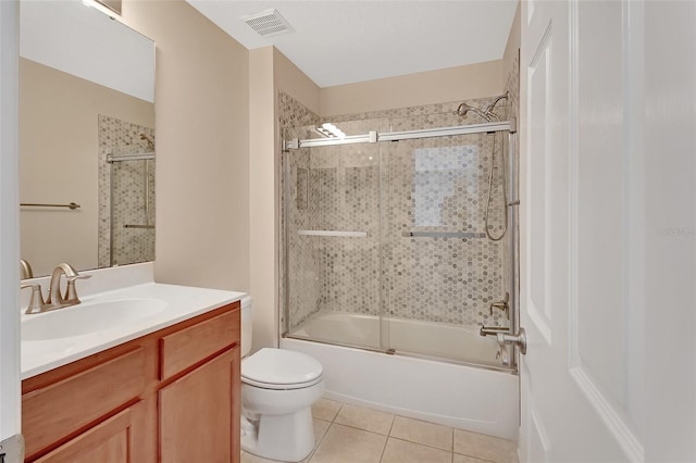 bathroom featuring visible vents, toilet, enclosed tub / shower combo, tile patterned floors, and vanity