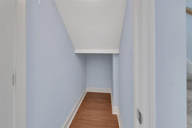 interior space with a textured ceiling, baseboards, and wood finished floors