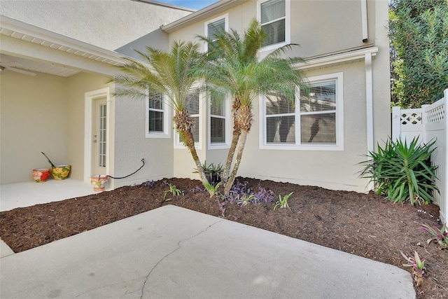 view of home's exterior featuring fence, a patio, and stucco siding