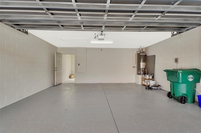 garage with a garage door opener, concrete block wall, and gas water heater