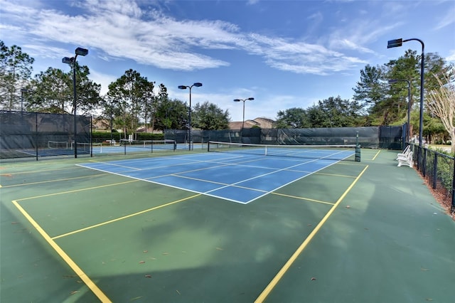 view of tennis court featuring fence