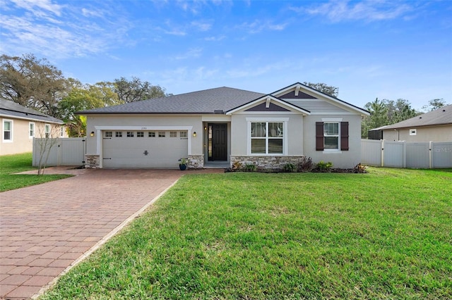 view of front facade featuring an attached garage, fence, stone siding, decorative driveway, and a front lawn