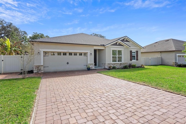 view of front of house with decorative driveway, stucco siding, a gate, a garage, and stone siding