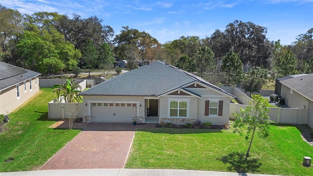 single story home with a fenced backyard, a gate, a front lawn, and decorative driveway