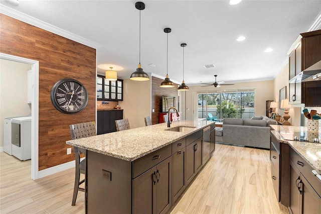 kitchen with ornamental molding, a sink, and wooden walls