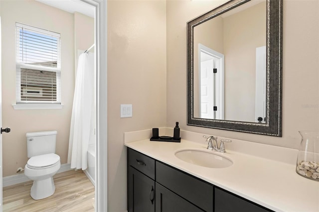 bathroom featuring toilet, wood finished floors, vanity, and baseboards