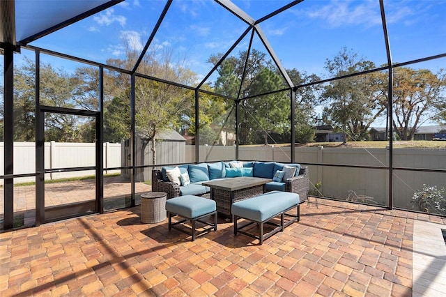 view of patio with outdoor lounge area, a fenced backyard, an outdoor structure, and a lanai