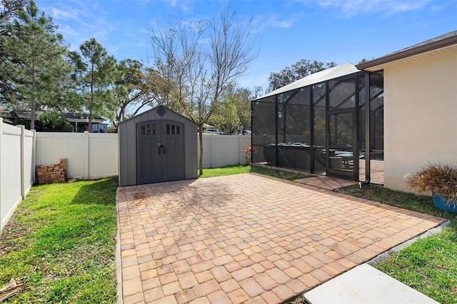 view of patio with a lanai, a storage shed, a fenced backyard, and an outdoor structure