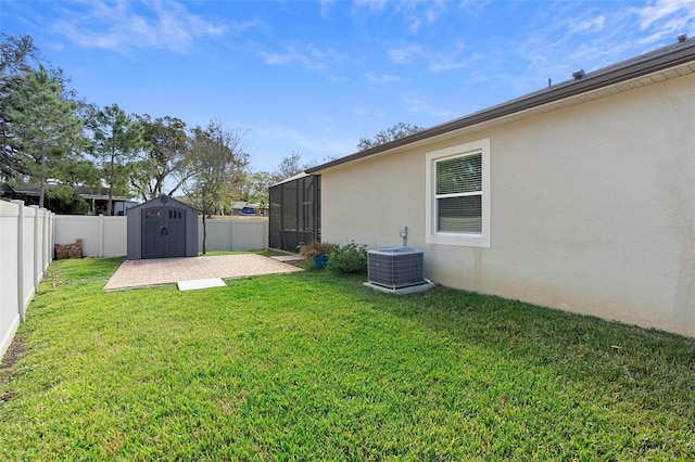 view of yard with a storage shed, a patio, a fenced backyard, cooling unit, and an outdoor structure