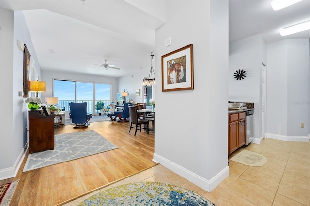 interior space featuring a ceiling fan, baseboards, and light tile patterned floors