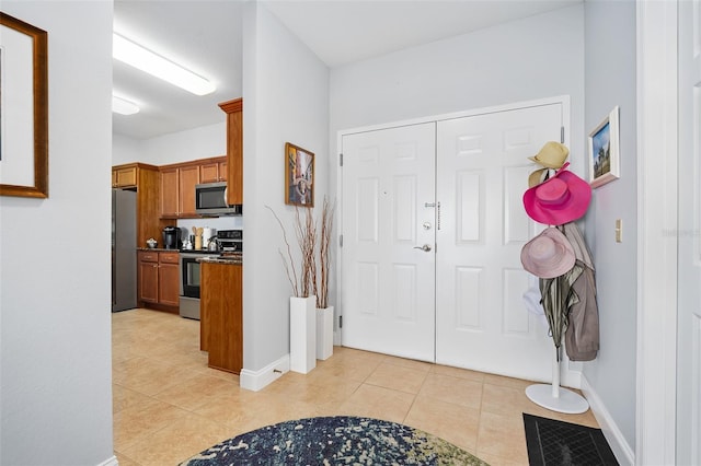 foyer with light tile patterned flooring, visible vents, and baseboards