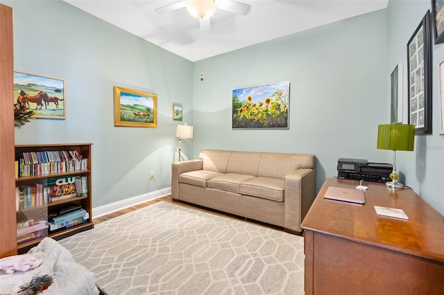 living room featuring a ceiling fan, light wood-type flooring, and baseboards