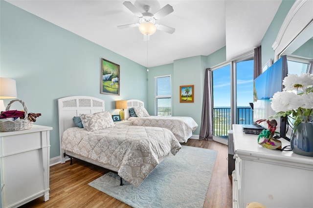 bedroom with baseboards, ceiling fan, wood finished floors, and access to exterior