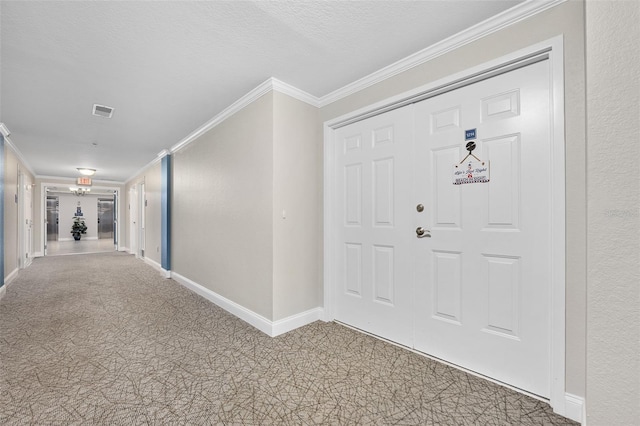 entryway with baseboards, a textured ceiling, visible vents, and crown molding