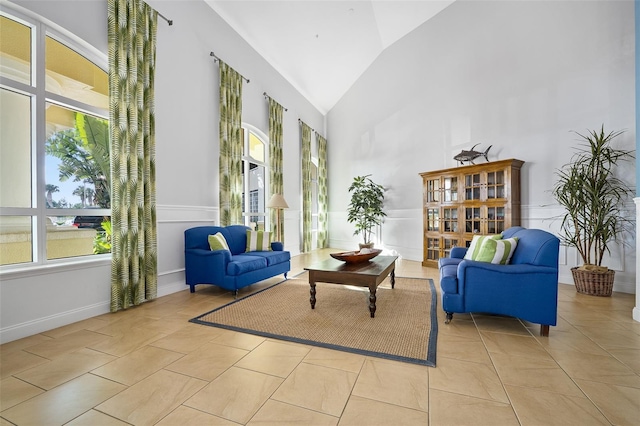 living area with high vaulted ceiling and light tile patterned floors