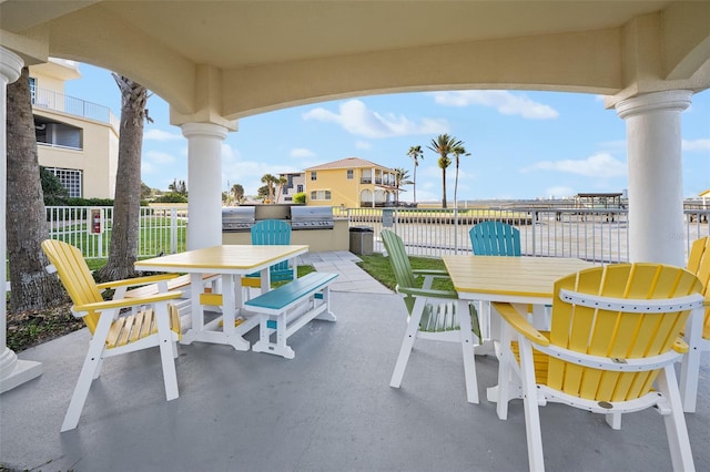 view of patio with outdoor dining space, a grill, and fence