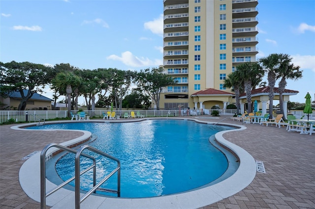 community pool featuring fence and a patio