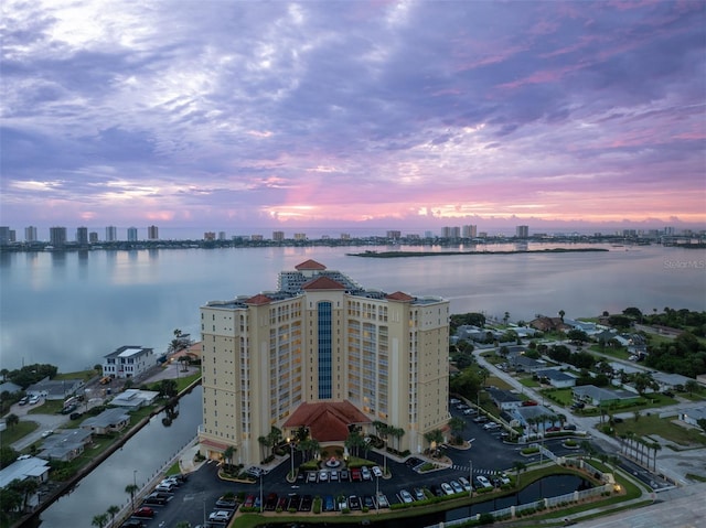 aerial view at dusk with a water view and a city view