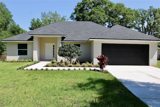 view of front of property with a front lawn, roof with shingles, an attached garage, and stucco siding