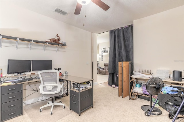 office with light colored carpet, visible vents, ceiling fan, and a textured ceiling