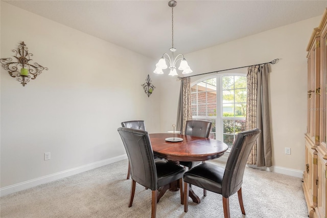 dining space featuring a chandelier, light colored carpet, and baseboards