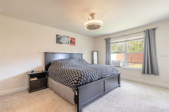 bedroom featuring baseboards, a textured ceiling, and light colored carpet