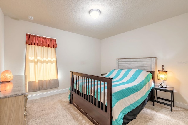 carpeted bedroom featuring a textured ceiling and baseboards