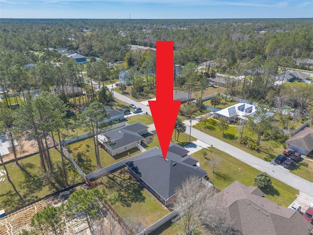 birds eye view of property featuring a wooded view and a residential view