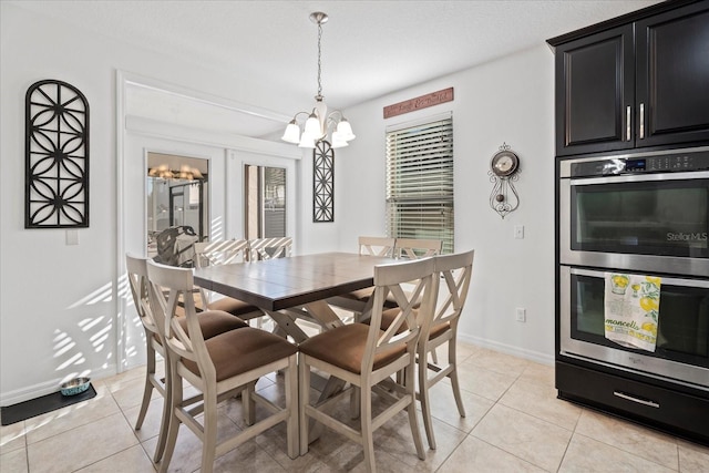 dining area featuring light tile patterned floors, baseboards, and a chandelier