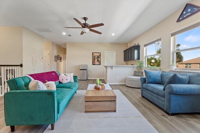 living room with light wood-style floors, recessed lighting, visible vents, and baseboards