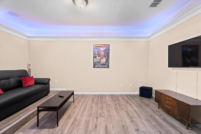 living room with light wood-style floors, a textured ceiling, visible vents, and crown molding