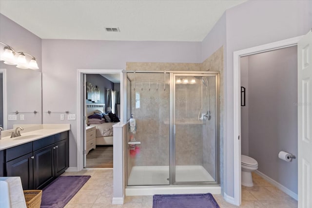 ensuite bathroom featuring visible vents, toilet, ensuite bathroom, a stall shower, and vanity