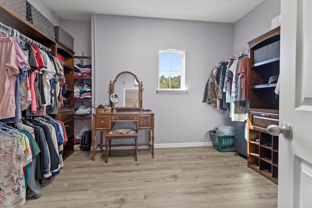 walk in closet with wood finished floors