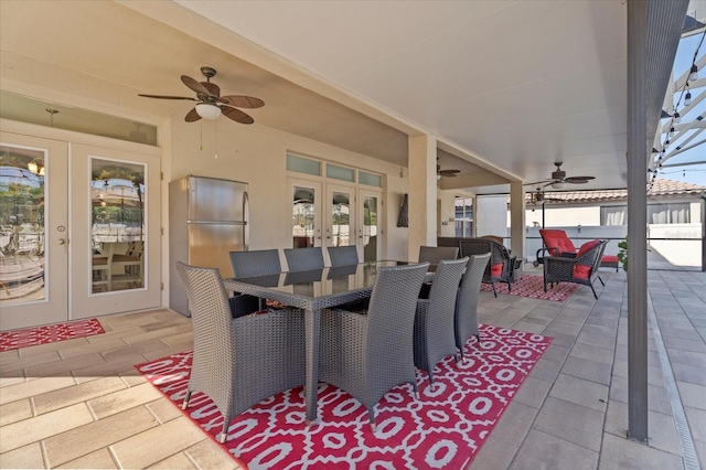 view of patio / terrace with outdoor dining area, a ceiling fan, and french doors