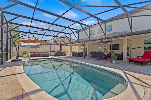 view of pool featuring ceiling fan, glass enclosure, outdoor lounge area, a fenced in pool, and a patio area