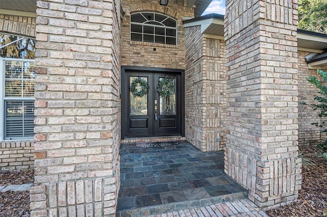 doorway to property featuring french doors and brick siding