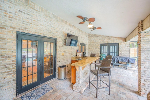 view of patio with outdoor dry bar, ceiling fan, french doors, and fence