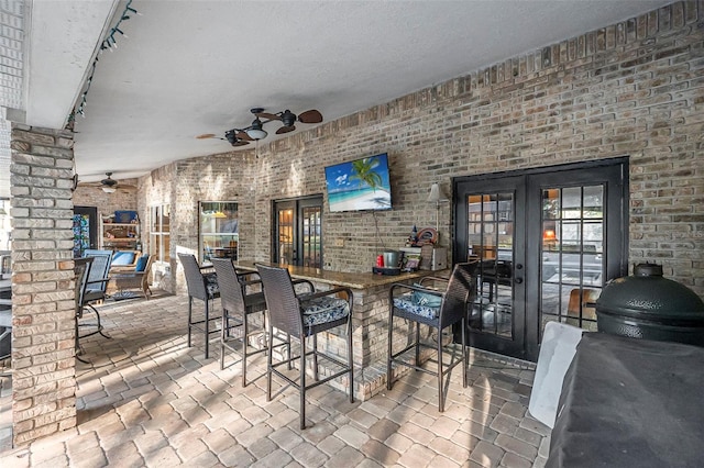 view of patio with grilling area, ceiling fan, outdoor dry bar, and french doors