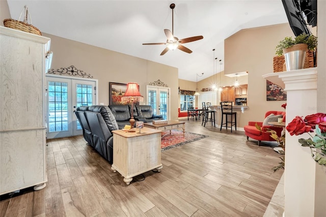 living area with high vaulted ceiling, french doors, wood finished floors, and a ceiling fan