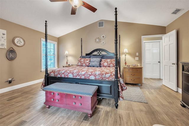 bedroom featuring light wood-type flooring, lofted ceiling, and visible vents