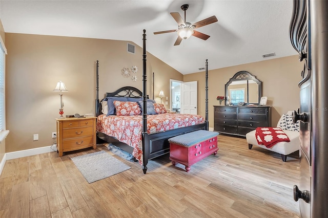 bedroom featuring light wood-type flooring, visible vents, lofted ceiling, and baseboards