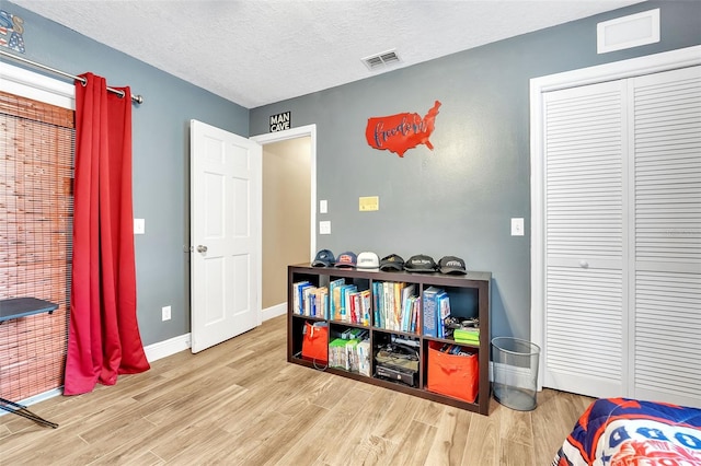 game room featuring baseboards, a textured ceiling, visible vents, and wood finished floors