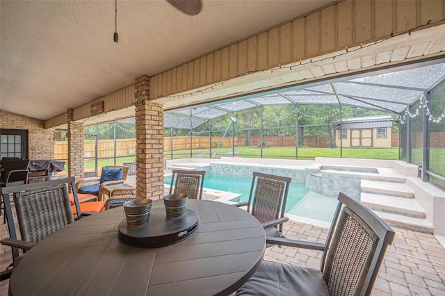 view of patio with a fenced backyard, an in ground hot tub, an outdoor structure, a shed, and outdoor dining space