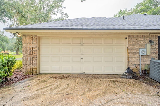 garage with cooling unit and concrete driveway