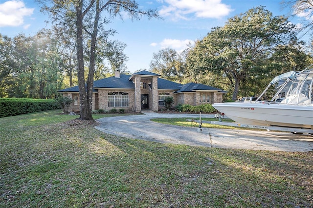 view of front of house with driveway, a front lawn, and a chimney